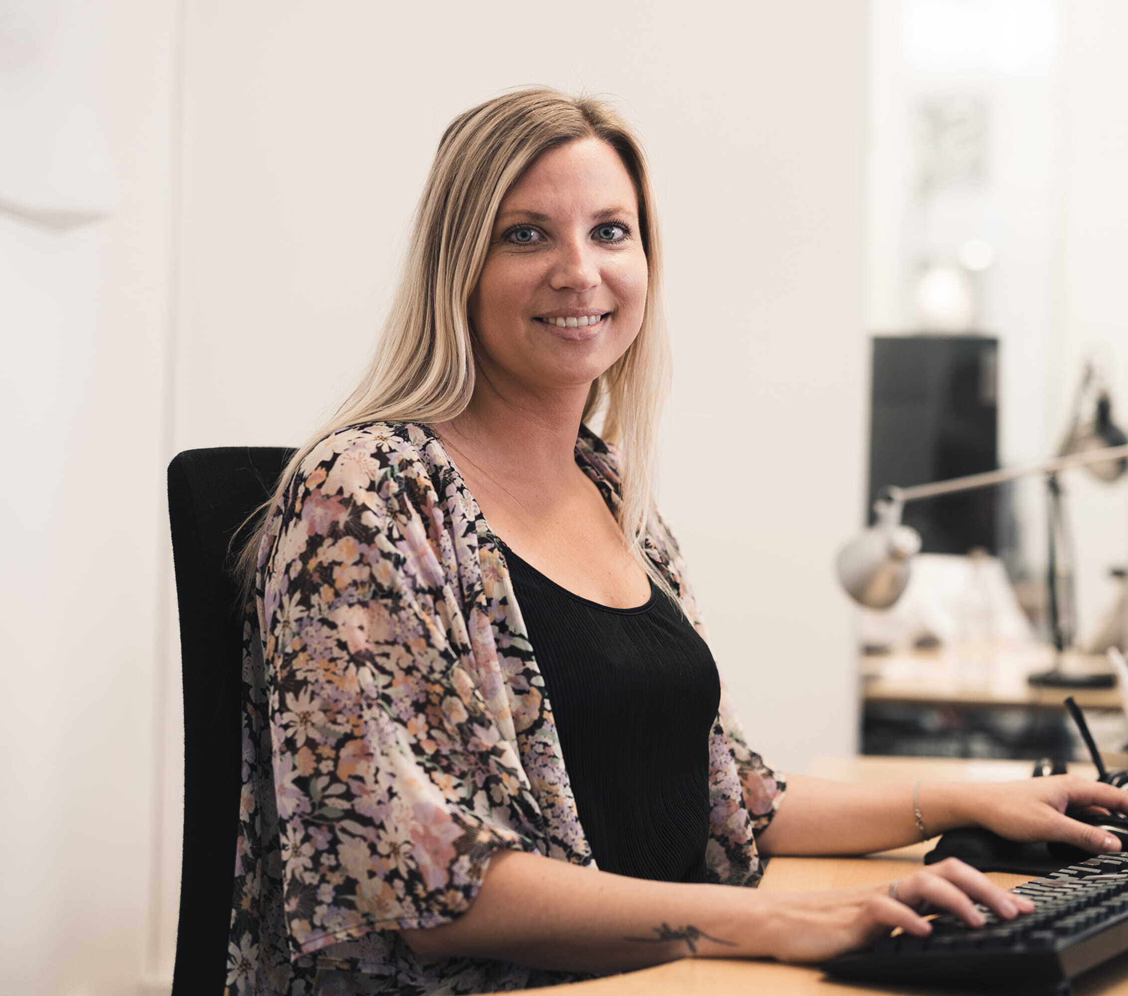 En person arbetar vid ett skrivbord med dokument och en laptop