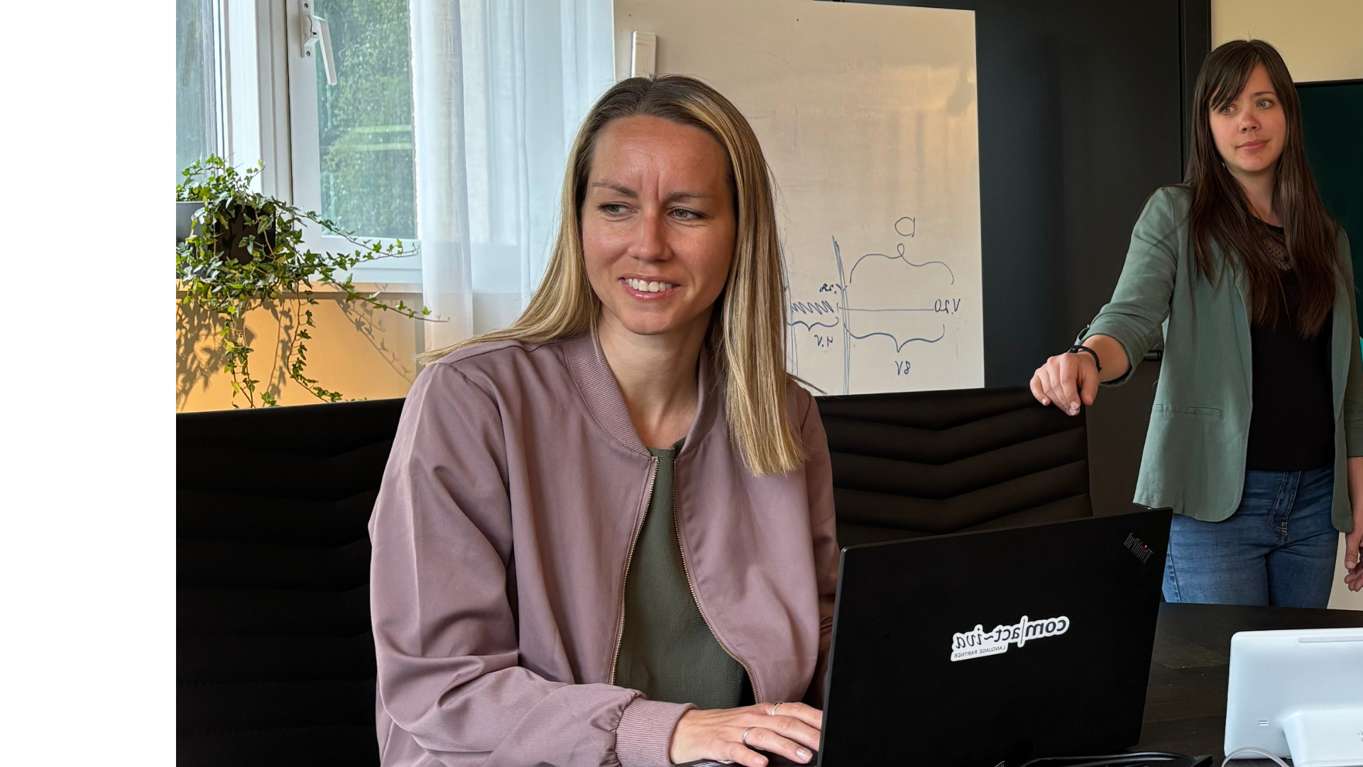 Sofia Johansson sitter vid ett bord med en dator framför sig och tittar åt vänster